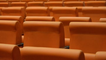 a row of orange seats in a theater